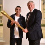 Anand V Khistariya holding the official Olympic Torch with University's vice-chancellor professor Neil Gorman