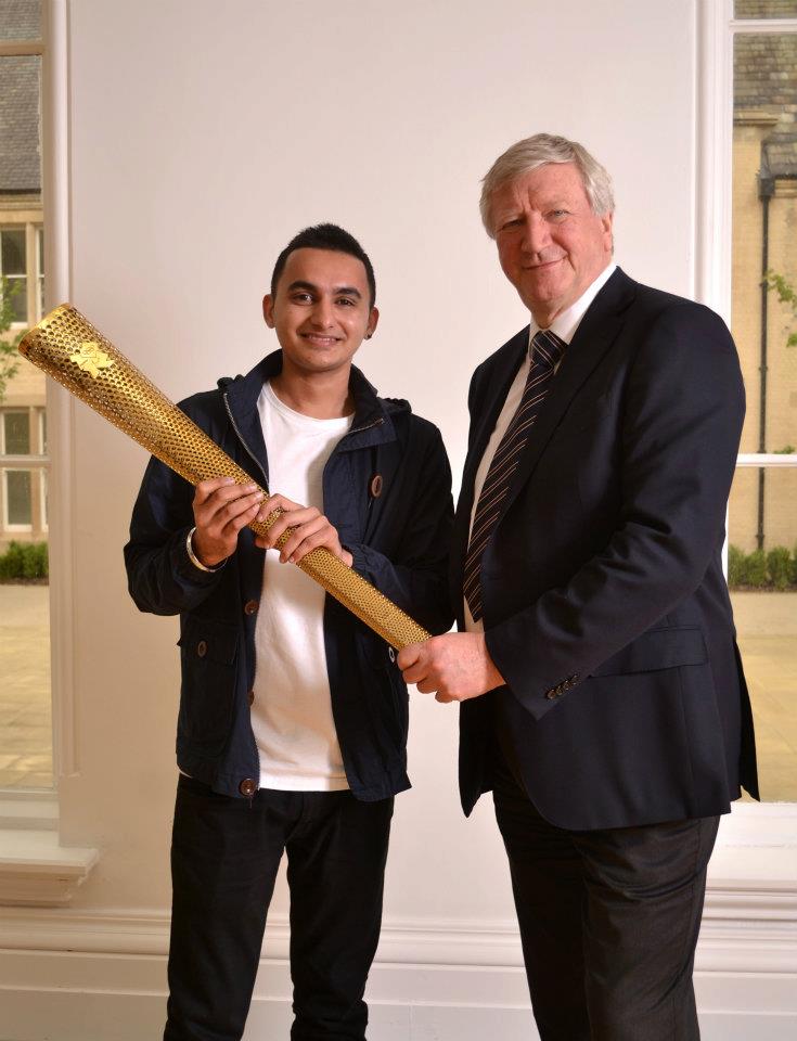 Anand V Khistariya holding the official Olympic Torch with University's vice-chancellor professor Neil Gorman